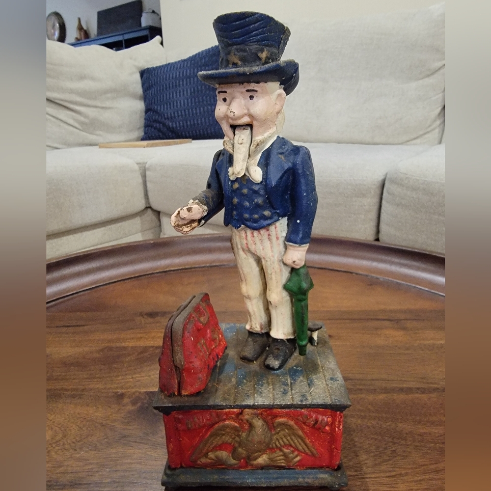 Vintage-style cast iron mechanical coin bank featuring the figure of Uncle Sam.